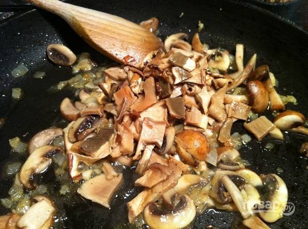 1. Грибочки вымойте, обсушите и нарежьте средними кусочками. Очистите и измельчите лук с чесноком. Разогрейте на сковороде растительное масло. Выложите лук с чесноком, обжарьте до прозрачности и добавьте грибы.
