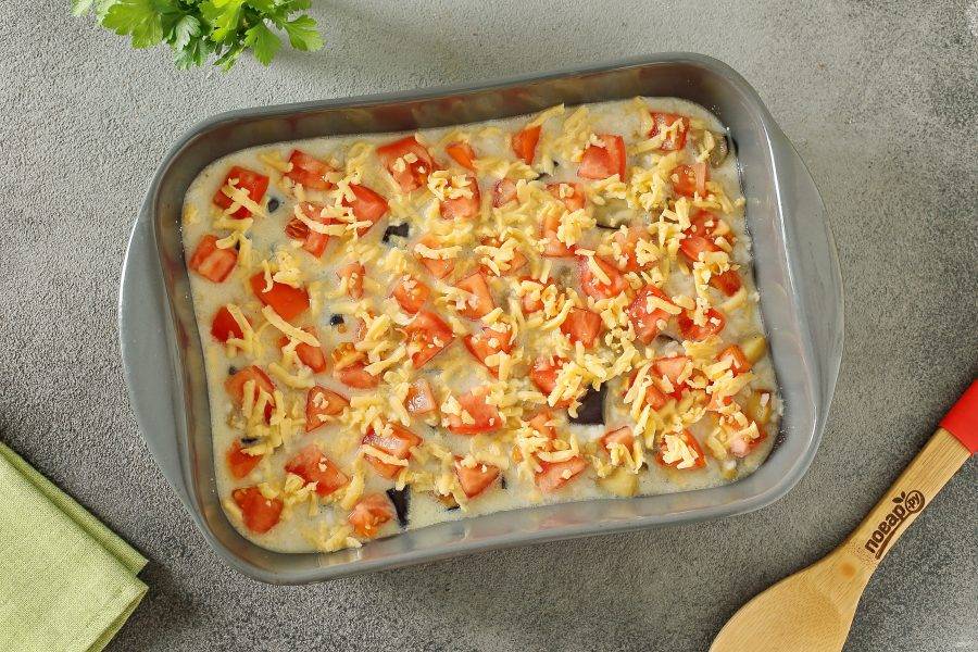 Сверху равномерно распределите нарезанные помидоры и посыпьте все оставшимся сыром. Запекайте в духовке при температуре 180 градусов около 30 минут.