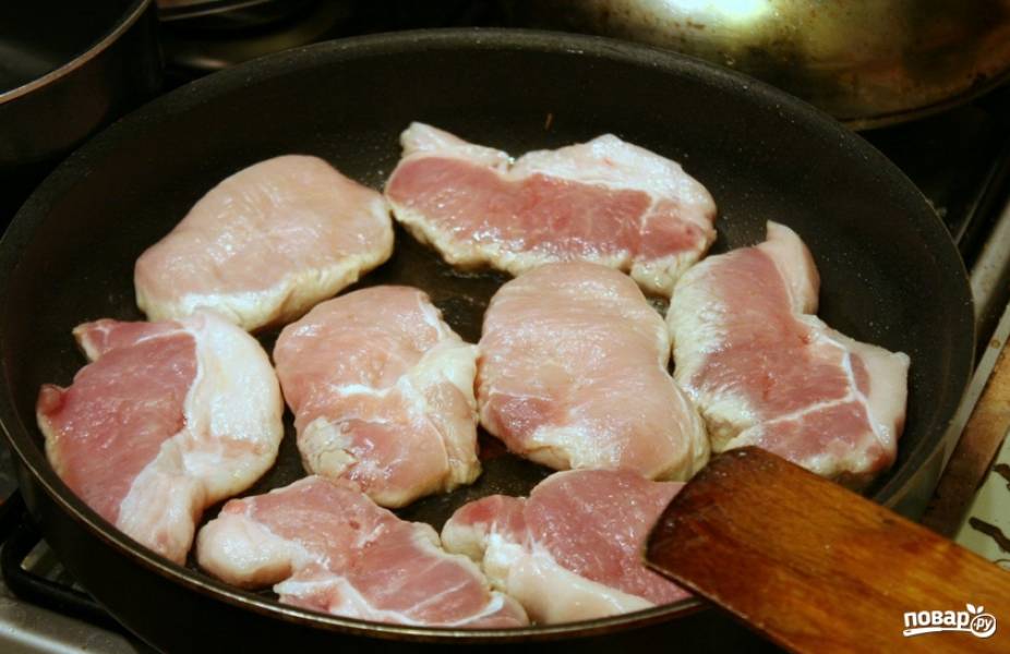 Мясо промываем и обсушиваем салфетками. Разогреваем в сковороде масло и выкладываем кусочки свинины.
