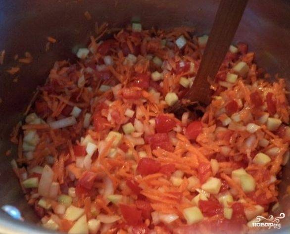 Дальше смешиваем в кастрюле морковь, лук, помидоры и кабачки. Добавляем туда растительное масло и ставим на средний огонь обжаривать минут на 7-10.