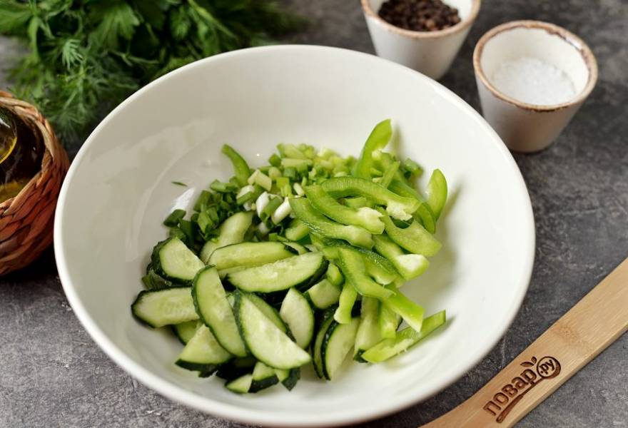 Почистите перец от семечек и плодоножки, нарежьте его тонкой соломкой, огурец нарежьте ломтиками, измельчите зеленый лук. 