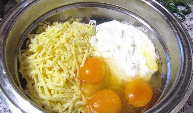 В одной емкости соедините сыр, сметану и яйца. Тщательно все взбейте венчиком до однородной массы.