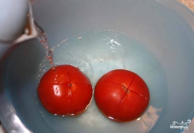 2. С помидоров снять кожуру. Существует один нехитрый способ, как это сделать легко: делаем на помидорах надрез в форме креста, кладем их в миску и заливаем кипятком. Оставляем на пару минут. Далее сливаем воду и с легкостью снимаем кожуру. 