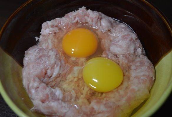 2. В фарш добавим немного лука, 2 яйца и специи по вкусу. Замешаем в однородную массу.