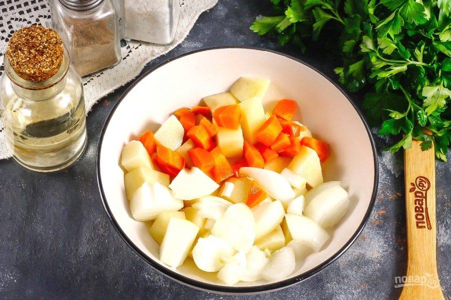 Нарежьте тыкву и картофель крупными кубиками, морковь — средними, а лук — полукольцами. Перемешайте нарезки в глубокой емкости, посолив и сбрызнув растительным маслом.