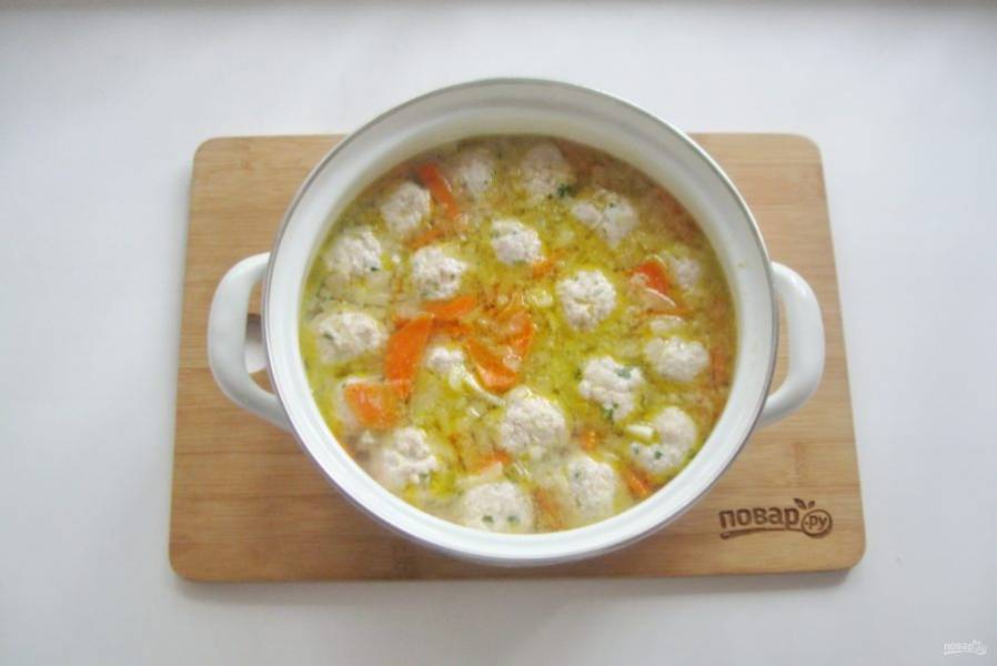 Выложите фрикадельки в кипящий суп. Посолите по вкусу.