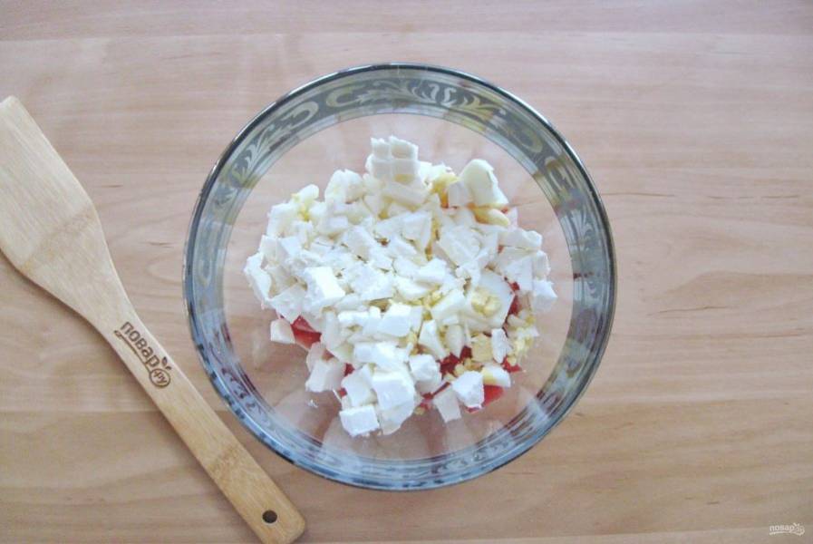 Брынзу нарежьте небольшими кубиками и добавьте в салатник.