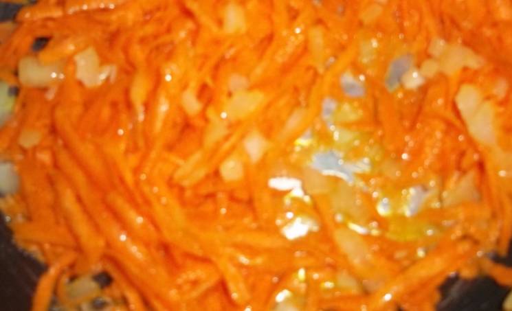 Разогрейте в сковороде растительное масло и обжарьте измельченный лук и морковь, добавив к ним томатную пасту.