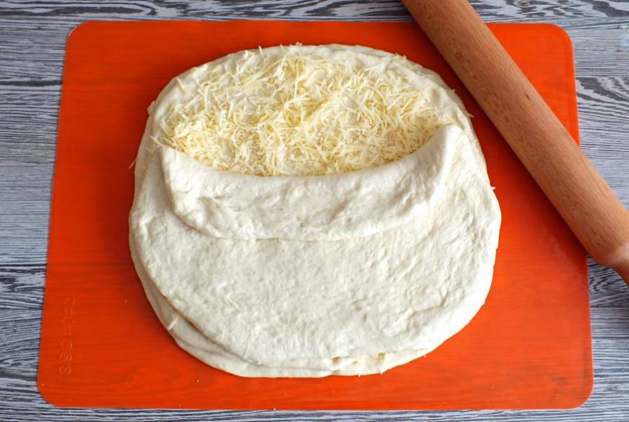 Посыпьте сверху сыр, закройте третьим пластом теста.