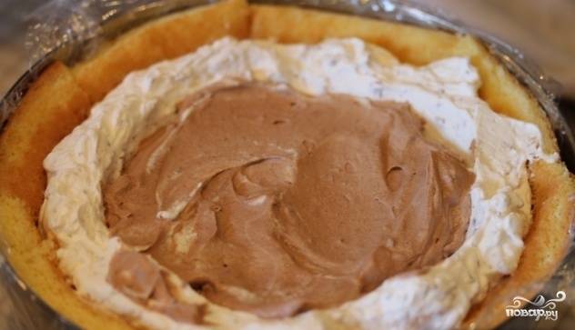 Заполните бисквитную основу полученным кремом, поместите её в холодильник. Оставшийся шоколад растопите на водяной бане и смешайте со сливкам. Полученную начинку выкладывайте в центр десерта.