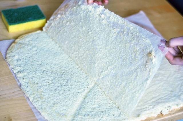 8. Переверните на лист пергамента с сахаром и аккуратно снимите лист, на котором бисквит выпекался. 