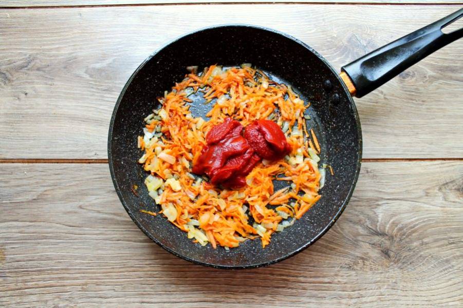 Добавьте в сковороду томатную пасту, перемешайте и обжаривайте еще одну минуту.
