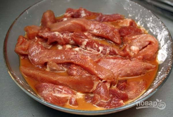 2.	Каждый ломтик свинины нарезаю полосками размером 1,5 сантиметра. В миске смешиваю крахмал, соевый соус, имбирный порошок и сахар, все тщательно перемешиваю и опускаю кусочки мяса.