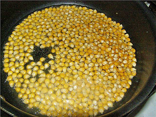 1. Разогреваем растительное масло на сковороде, выкладываем кукурузу и закрываем крышкой. 