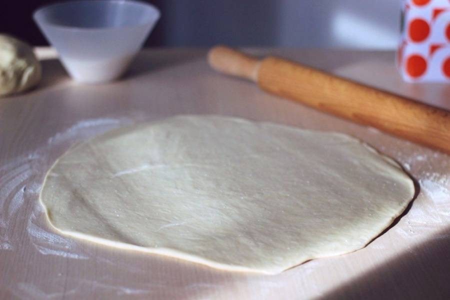 Когда тесто отстоялось, разделяем его на две части для удобства раскатывания.
Поверхность также можно немного присыпать мукой.
Раскатываем тесто. Чем тоньше вы его раскатаете, тем меньше будут ваши печеньки по размеру, поэтому оптимальную толщину задаете сами.