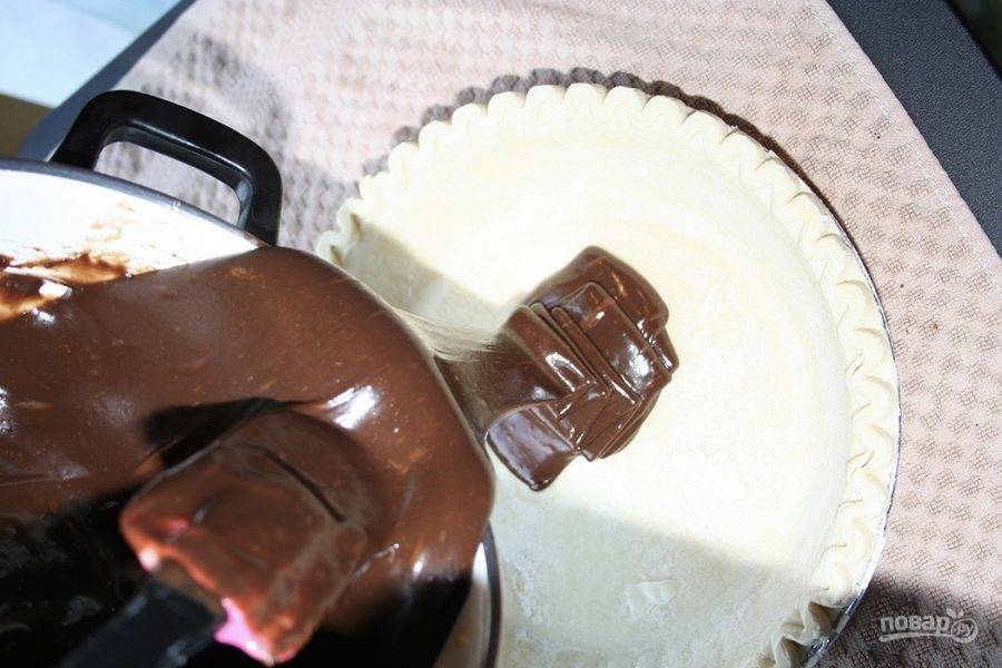 Размороженное тесто раскатайте и уложите в форму, в которой будете выпекать будущий пирог. Влейте на уложенное тесто шоколадно-молочную начинку.