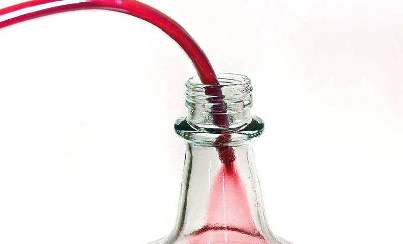Тонкую фильтрацию черничного вина проводят раз в 10-12 дней при помощи переливания жидкости из одной емкости в другую. При этом нужно стараться не затронуть осадок.