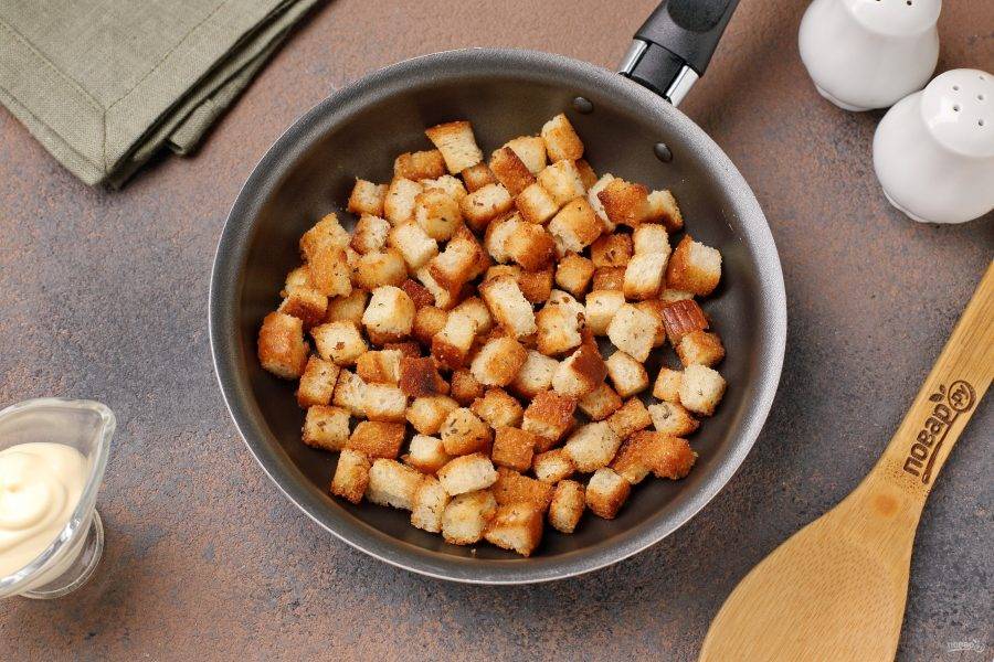 Батон нарежьте мелкими кубиками и обжарьте на хорошо разогретой сковороде с растительным маслом. В процессе посолите, можно так же добавить ароматные специи (у меня прованские травы). Переложите готовые сухарики пока на тарелку.