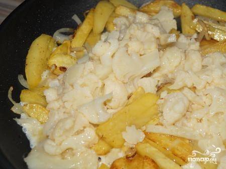 Через 5 минут к картофелю добавьте капусту с яйцом. Жарьте блюдо на сильном огне в течение трёх минут.