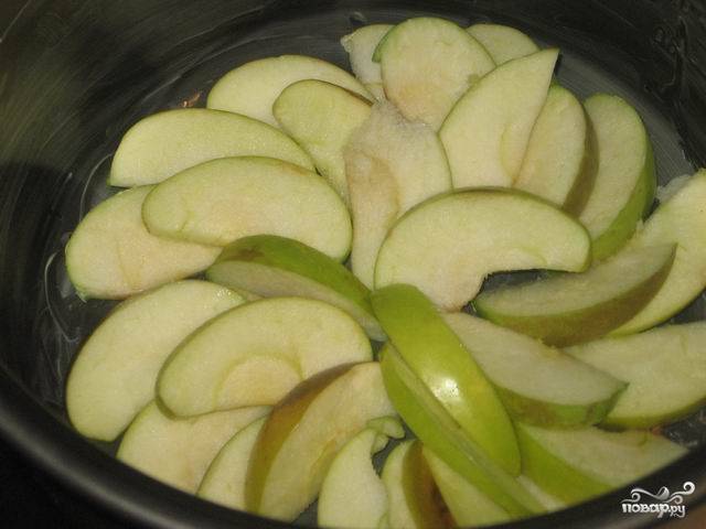 2. Чашу мультиварки обильно смазать сливочным маслом, можно немного присыпать мукой. 
На дно формы аккуратно выложить яблоки.