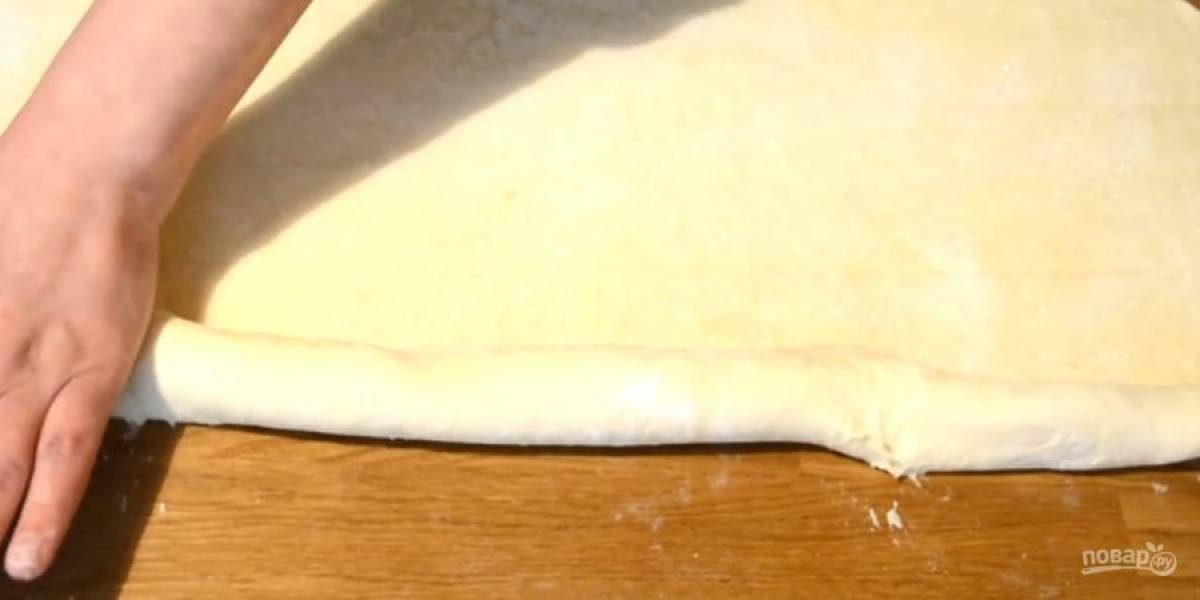 4. Раскатайте тесто в пласт толщиной 0,5 см, сверху присыпьте сахаром и слегка пройдитесь скалкой. С обеих сторон скатайте пласт в рулетики к центру. Снова положите тесто в холодильник на 10 минут или в морозилку на 5 минут. 