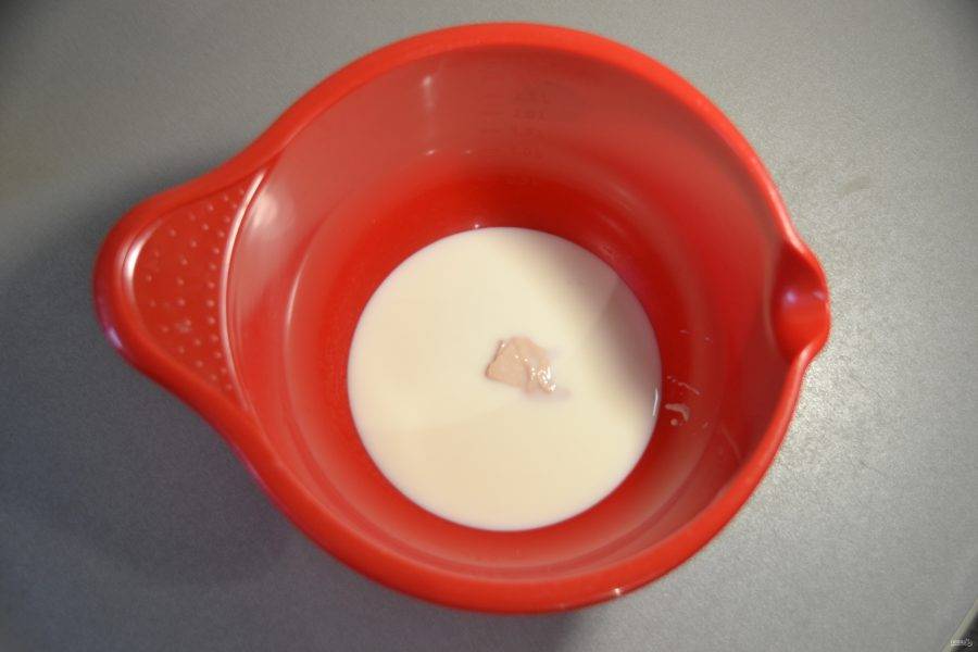 Влейте в миску теплое молоко и положите в него дрожжи, размешайте до растворения дрожжей. Затем всыпьте соль и сахарный песок, перемешайте до растворения.