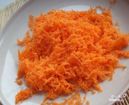 Морковку очищаем и трем на мелкой терке, затем отправляем её к овощам на сковороду.