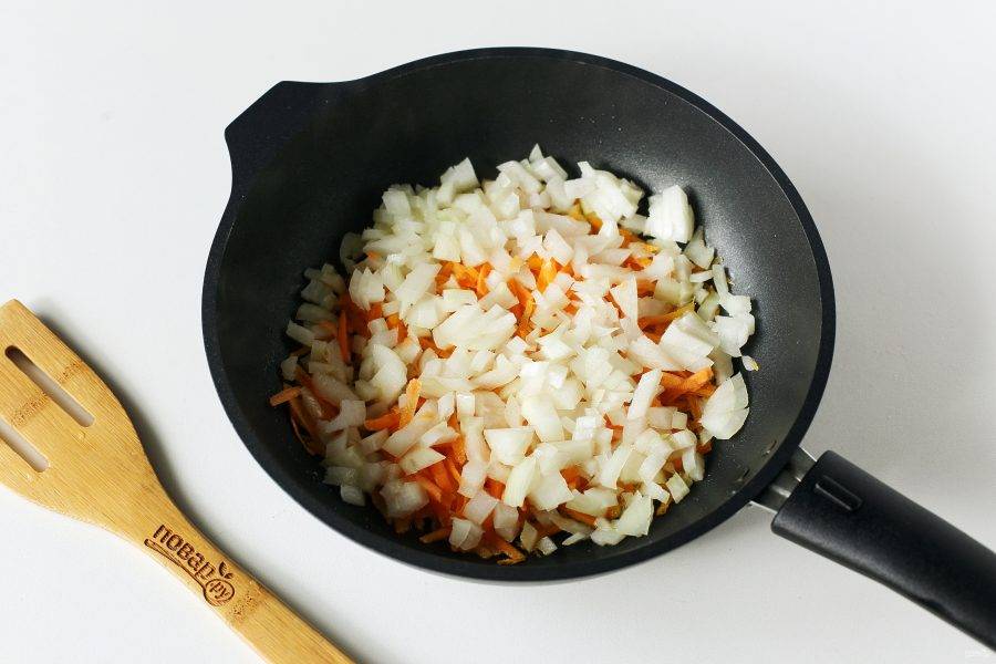 В сковороде разогрейте масло. Выложите тертую морковь и нарезанный кубиками лук.