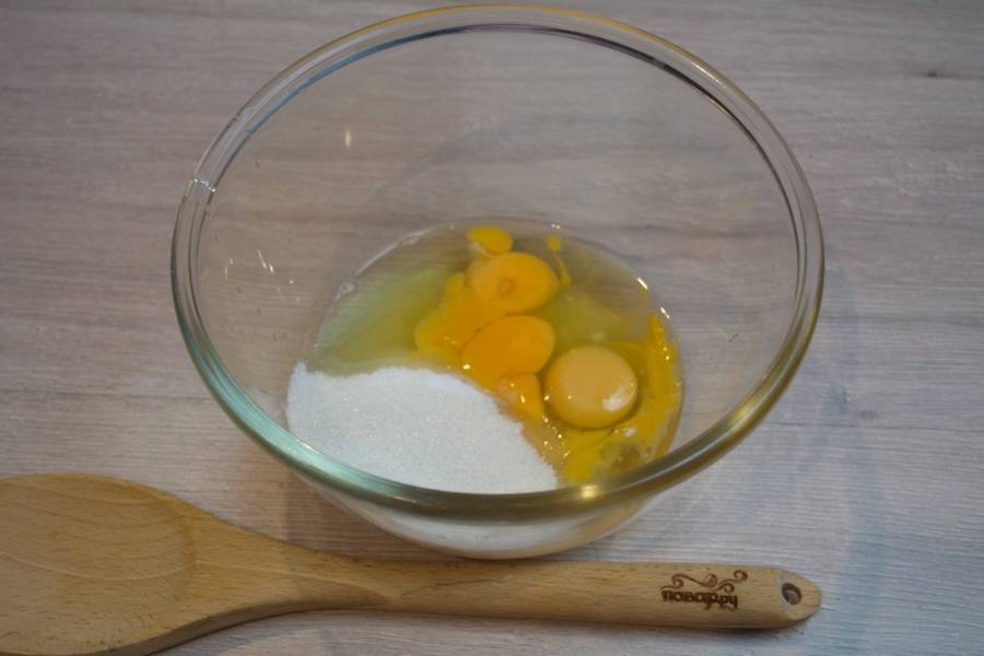 1. Для приготовления шарлотки с бананами нам необходимо взять яйца. Вбейте яйца в миску. Добавьте сахар, соль, разрыхлитель. 