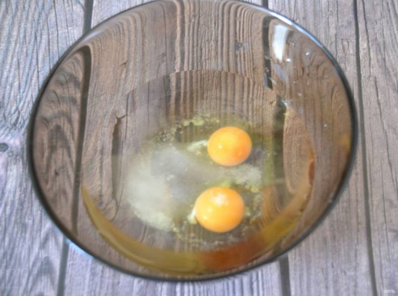 В миску влейте воду, добавьте соль, сахар, вбейте 2 яйца, взбейте.