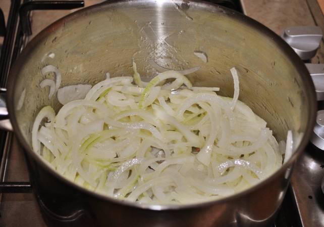 1. Лук чистим и нарезаем тонкими кольцами. В большую глубокую сковороду выложите сливочное масло и влейте оливковое. Жарьте лук на медленном огне в течение 15-20 минут, пока он не начнет менять цвет на золотистый.