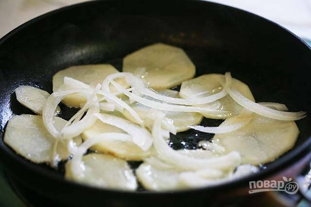 1.	Картофель очистите от кожуры и нарежьте тонкими кружочками. Очистите лук от шелухи, затем нарежьте его тонкими кольцами. Сковороду отправьте на огонь, разогрейте с растительным маслом. Выложите картофель в один слой, затем добавьте лук. 
