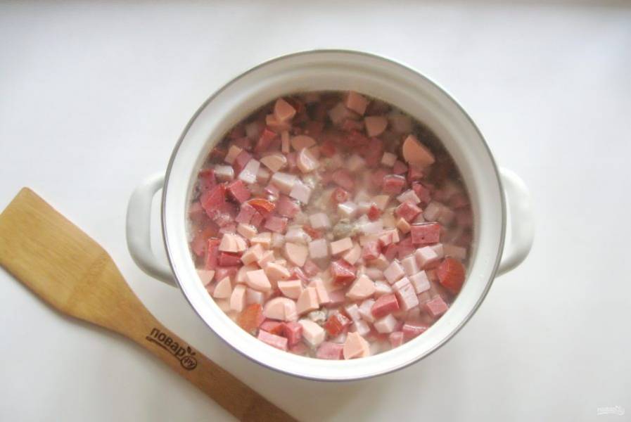 Нарезанную колбасу, желудки и курицу выложите в кастрюлю с картофелем и бульоном.