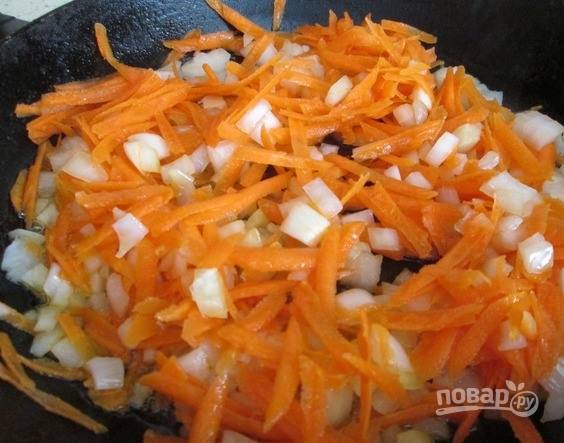 В сковороду влейте растительное масло и разогрейте его на плите. Морковь поскоблите ножом, вымойте и натрите на крупной терке. Лук очистите и нарубите кубиками, как можно мельче. Подготовленные овощи выложите в сковородку и обжарьте до мягкости. 