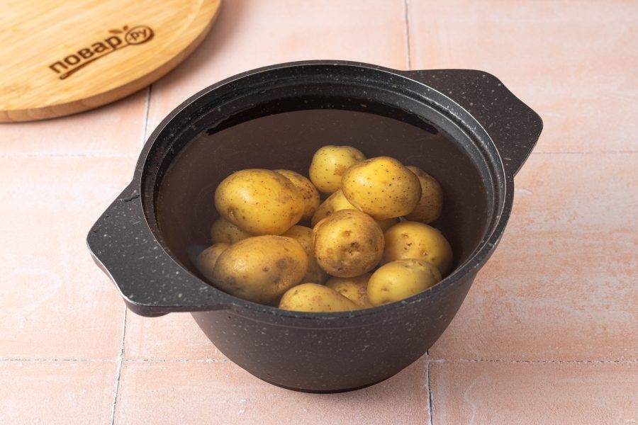 Картофель тщательно помойте, переложите в кастрюлю и залейте чистой водой. Доведите до кипения и отваривайте 5 минут.