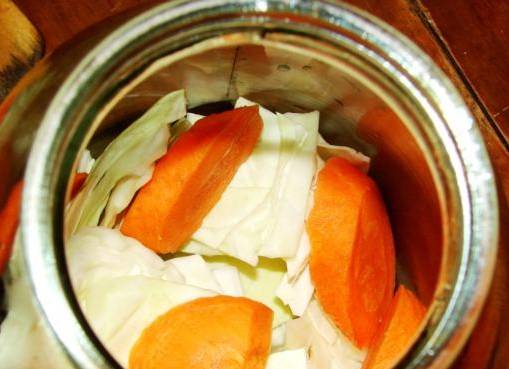 2. Далее закладываем крупно порезанную капусту и кружочки морковки. Овощи плотно укладываем до самых "плечиков" банки. 