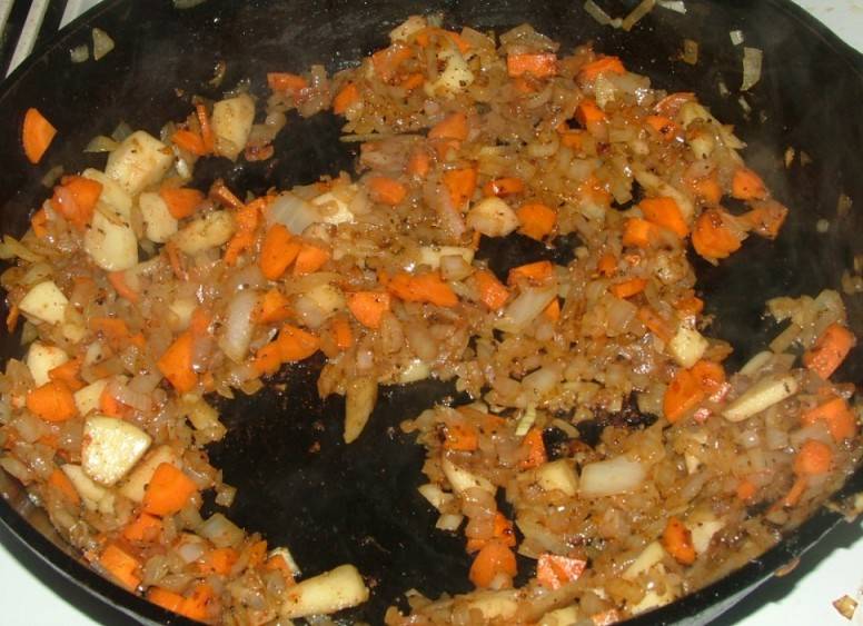 Далее нарезаем репчатый лук на четверть кольца, выкладываем его на сковороду, где жарилось мясо. Обжариваем лук до румяности и добавляем к нему нарезанную четверть кольцами морковь, жарим все вместе еще пару минут. В самом конце выкладываем к овощам нарезанное на кусочки яблоко (без кожуры), добавляем специи и еще 1-2 минуты жарим все.