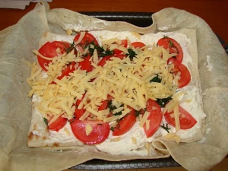 4. Теперь выкладываем поверх сыра помидор, посыпаем свежей зеленью, и сверху распределяем остатки натертого сыра. 