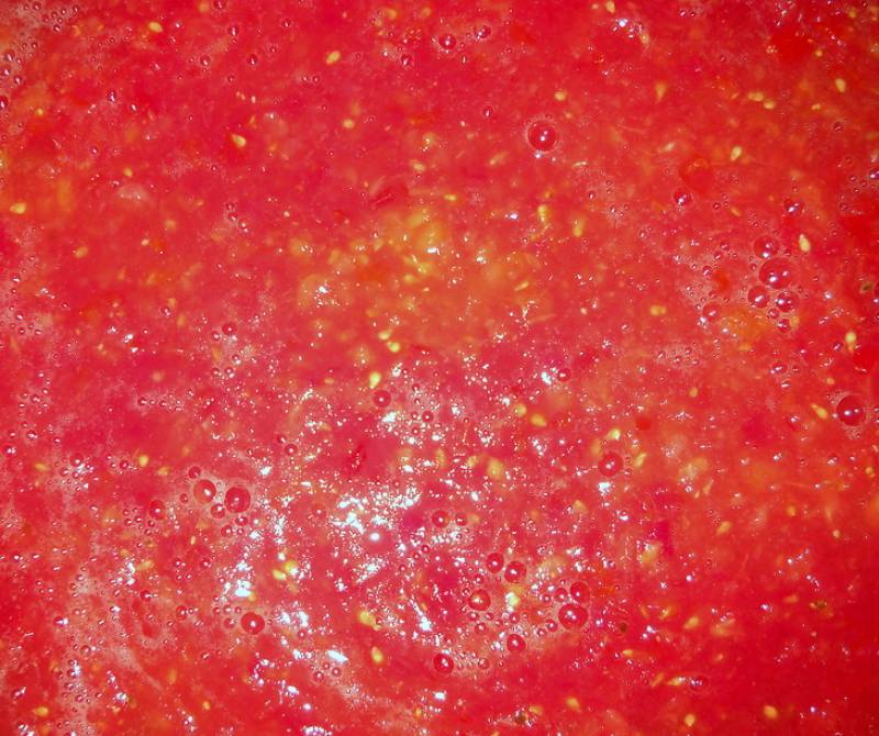 Измельчите помидоры в мясорубке.