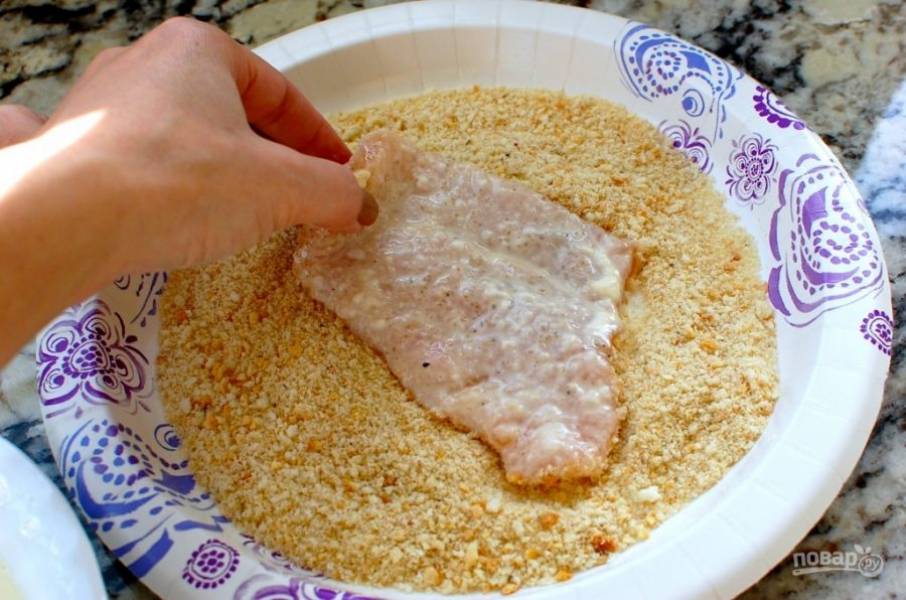 6.	Смешайте панировочный сухари с 2 столовыми ложками тертого Пармезана, обмакните каждый мясной кусочек в эту смесь.