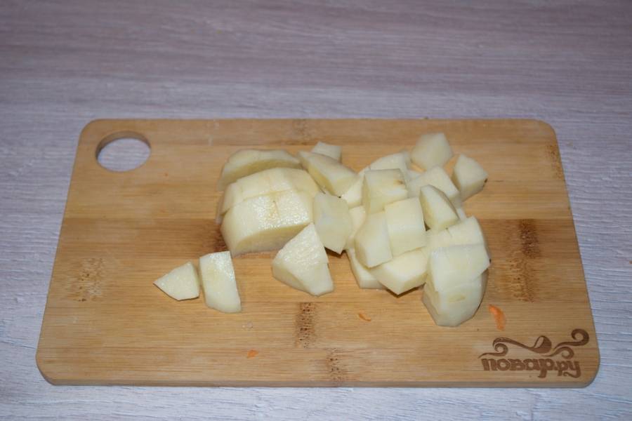 5. Картофель очистите и измельчите, нарежьте на небольшие кубики. Пока овощи тушатся, поместите картофель в кастрюлю. Залейте водой и поставьте вариться.