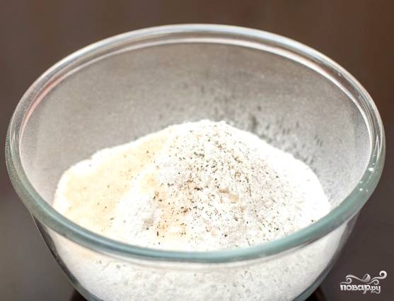 Взбиваем пару яиц в глубокой миске. Наливаем стакан молока, добавляем сахар. Взбиваем до получения пены. Муку просеиваем через сито. Досыпаем соль, разрыхлитель и черный молотый перец. 