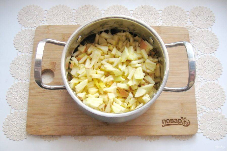 Выложите нарезанные яблоки в кастрюлю.