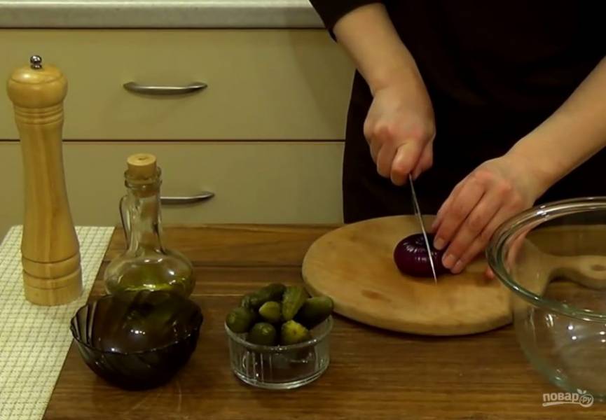 4. Приготовьте заправку: четвертинку сладкой луковицы нарежьте небольшими кубиками, добавьте нарезанные огурцы и оливковое масло. 