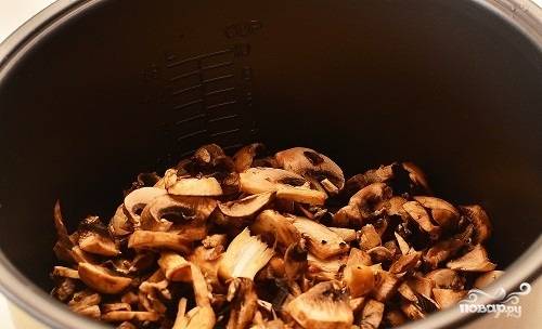 3.	В чашу мультиварки наливаем растительное масло, включаем режим «Жарка» или «Тушение». Когда нагреется, всыпаем лук и грибы.
