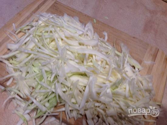 Нашинкуем капусту тонкой соломкой, добавим соль и сахар, помнем, чтобы капуста стала мягче и пустила сок.
