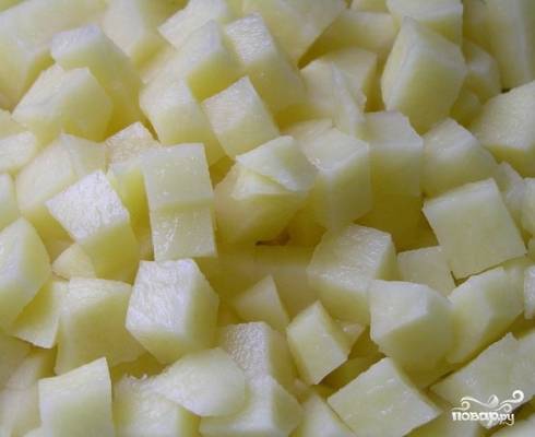 Очистим картофель, нарежем его небольшими кубиками и отправим в кипящий бульон.