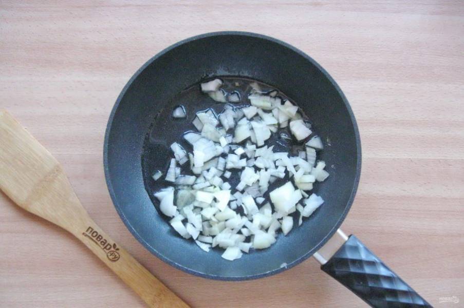 Репчатый лук очистите, помойте и мелко нарежьте. Выложите в сковороду. Налейте растительное масло и поджарьте лук до прозрачности.