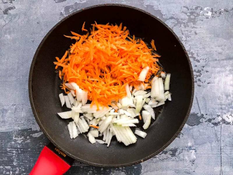 Лук очистите от шелухи и мелко нарежьте. Морковь помойте, обсушите бумажным полотенцем и натрите на средней терке. В хорошо разогретую сковороду с растительным маслом выложите овощи и обжарьте их в течение 8-10 минут.