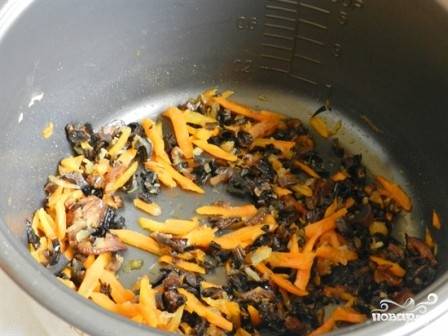 Наливаем в чашу мультиварки масло, включаем режим "Выпечка" на 20 минут. Добавляем лук, морковь и грибы. Обжариваем и не забываем помешивать.